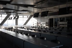 Rows of empty desks in a modern conference room.